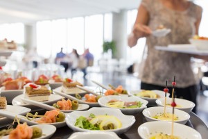 Ambijenti, buffet stol s dizajniranim zalogajima_dimljeni losos s punjenom maslinom_servirano na ukrasnim tanjurima